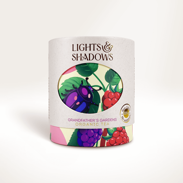 Grandfather's Gardens apple and berry fruit tea in a Lights & Shadows gift box with a beetle among raspberries and blackberries